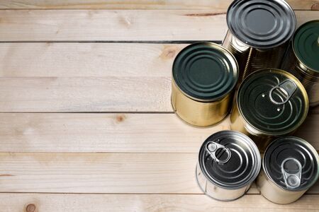 Tin cans for food on wooden background