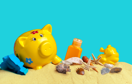 Summer piggy bank with sunglasses on the beachの写真素材