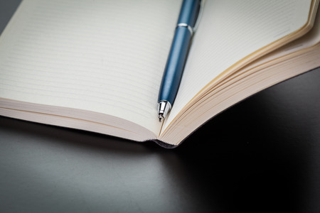 blank notebook and pen on the tableの写真素材