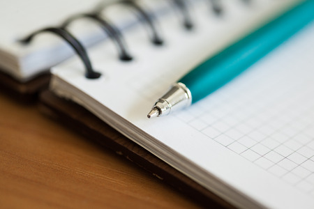 Blank note paper with pen on wood backgroundの写真素材