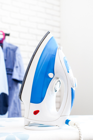 Electric iron and shirt, on cloth backgroundの写真素材