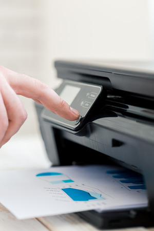 Man's hand making copies. Working with printer