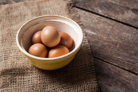 eggs in a bowl on the table from the old boardsの写真素材