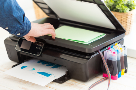 Man's hand making copies. Working with printer