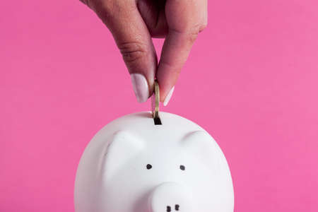 Inserting a coin into a piggy bank