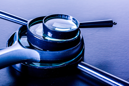 Closeup of magnifying glass on dark surfaceの写真素材