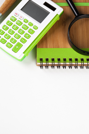Calculator with a magnifying glass on a white backgroundの写真素材
