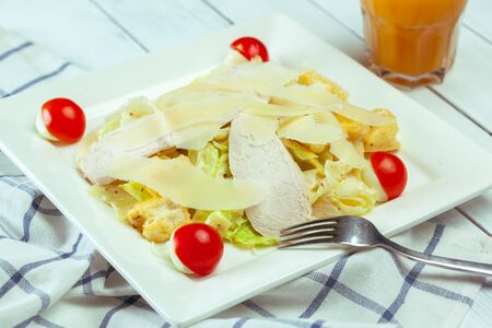 Caesar salad with chicken and greens on wooden tableの写真素材