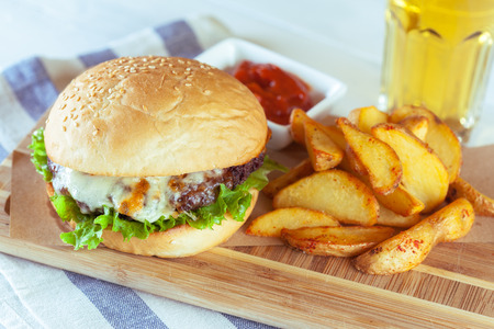 burger and french fries on wooden tableの写真素材