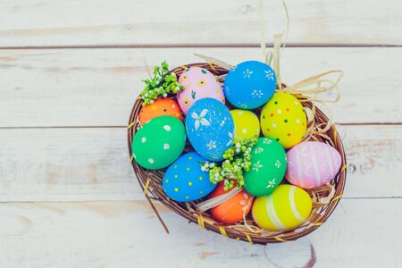 Easter eggs painted in pastel colors on white wooden background.の写真素材