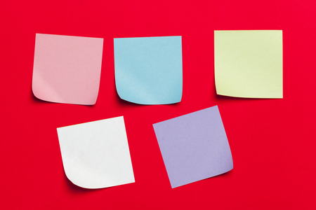 Reminder sticky notes on red backgroundの写真素材