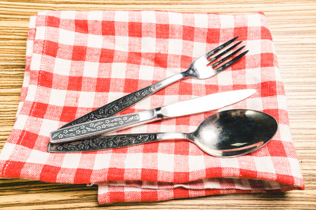 Fork and table knife on red gingham tableclothの写真素材