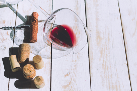 Wine glass, cork and corkscrew over wooden tableの写真素材