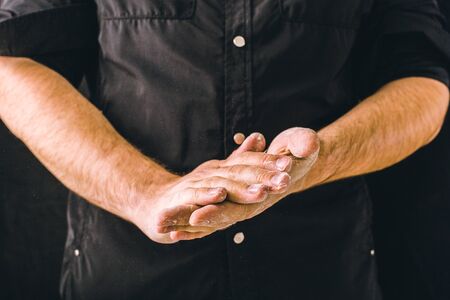hand clap and white flour on black backgroundの写真素材