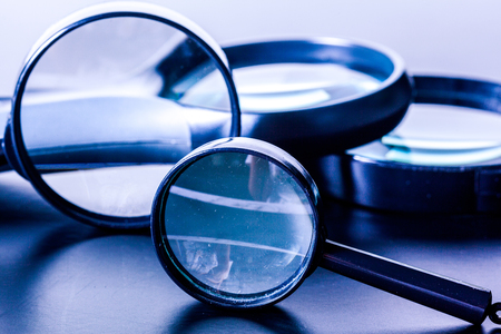 Closeup of magnifying glass on dark surfaceの写真素材