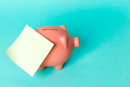 Piggy bank with empty sticky noteの写真素材
