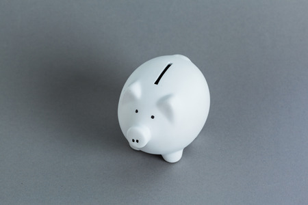 pink ceramic piggy bank over a grey background