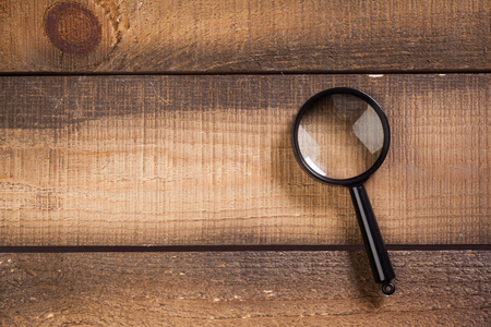 magnifying glass on the wooden backgroundの写真素材