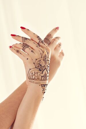 Red manicured hands with Mehndiの写真素材