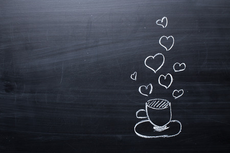 Tea cup drawn on a black dirty chalkboardの写真素材