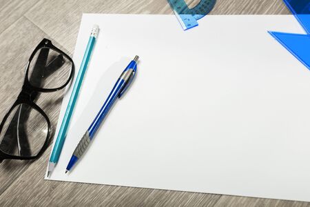 Blank notebook and pencil with glasses on wooden tableの写真素材