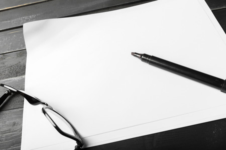 Blank notebook and pencil with glasses on wooden tableの写真素材