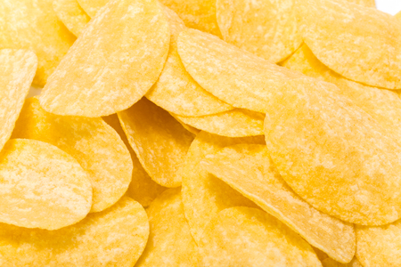 yellow potato chips isolated on whiteの写真素材