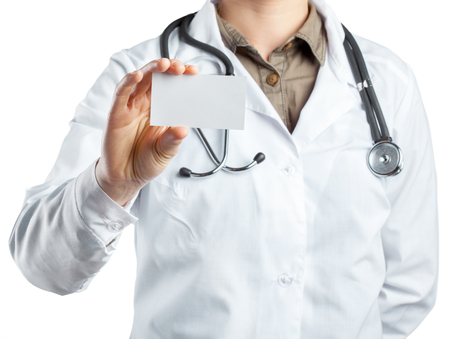 Doctor holding card with stethoscope isolatedの写真素材