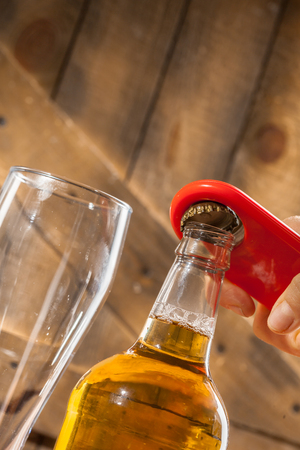 Glass bottle of beer and openerの写真素材