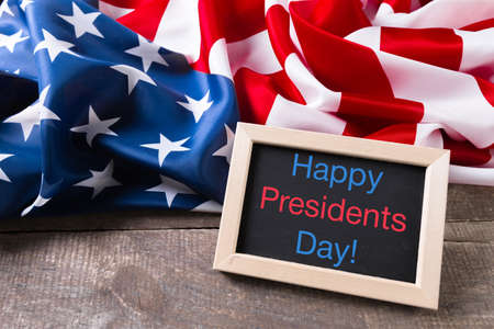 the text happy presidents day written in a chalkboard and a flag of the United States