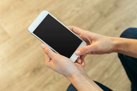 Woman with modern mobile phone in hands