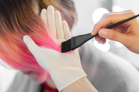 Hairdresser does hair style of womanの写真素材