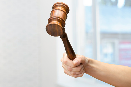 someones hand holding Wooden Law Gavelの写真素材