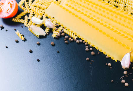 Raw spaghetti on black wooden background, top viewの写真素材