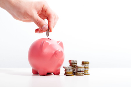Savings - Piggy bank and hand with coin