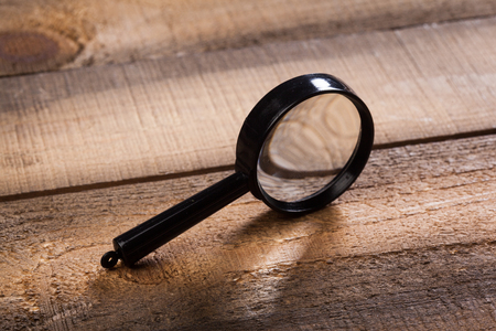 magnifying glass on the wooden backgroundの写真素材