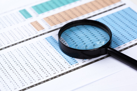 financial documents with magnifying glass over themの写真素材