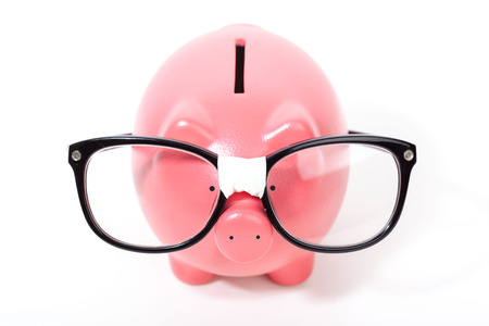 Pink piggy bank with glasses isolated on a whiteの写真素材