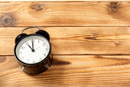 Black alarm clock on wooden tableの写真素材