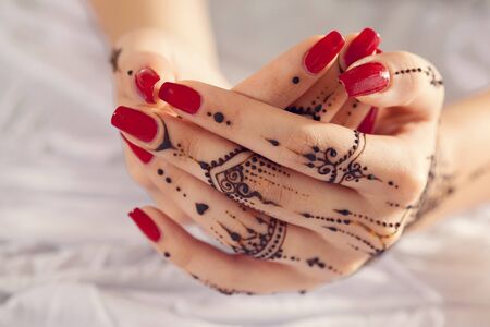 Red manicured hands with Mehndiの写真素材