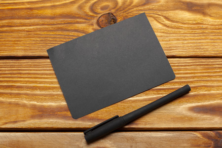 Mockup of black paper on wooden tableの写真素材