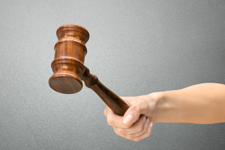someones hand holding Wooden Law Gavelの写真素材