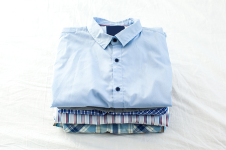 close up of ironed and folded shirts on table at homeの写真素材