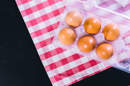 Eggs on tablecloth over black background