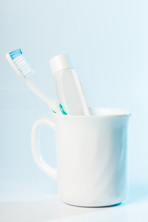 Toothbrushes in glass on table on light backgroundの写真素材