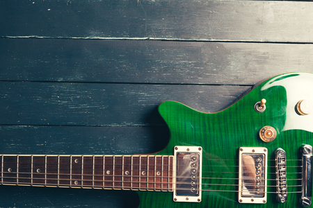 Electric guitar body and neck detail on wooden backgroundの写真素材