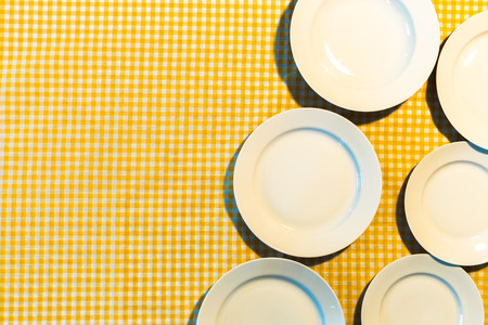 the plate on yellow checkered table clothの写真素材