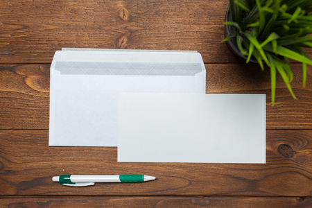 Blank paper, envelope on wooden tableの写真素材