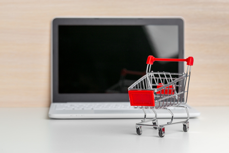 Shopping Cart On Laptop At Wooden Tableの写真素材