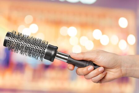 Female hand holding barber comb in cosmetic storeの写真素材